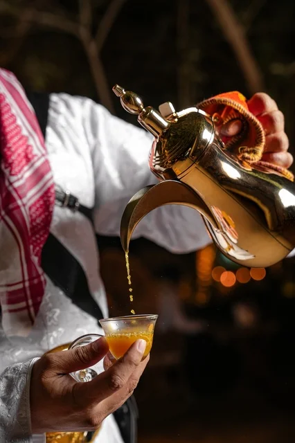 رجل سعودي يصب القهوة العربية من الدلة الذهبية