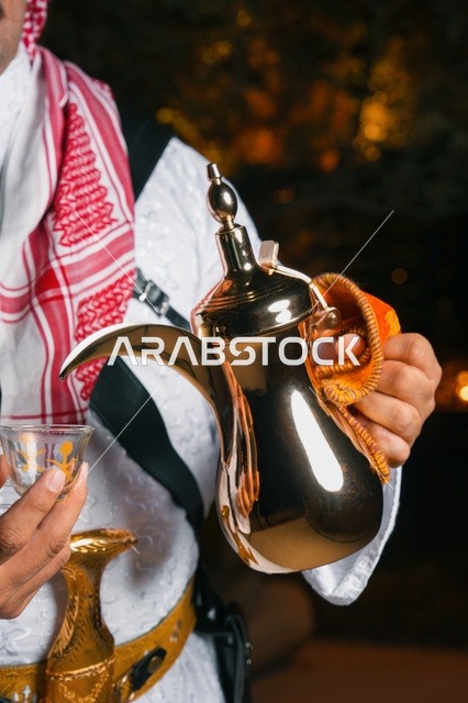 Saudi Man Pouring Arabic Coffee from Golden Dallah