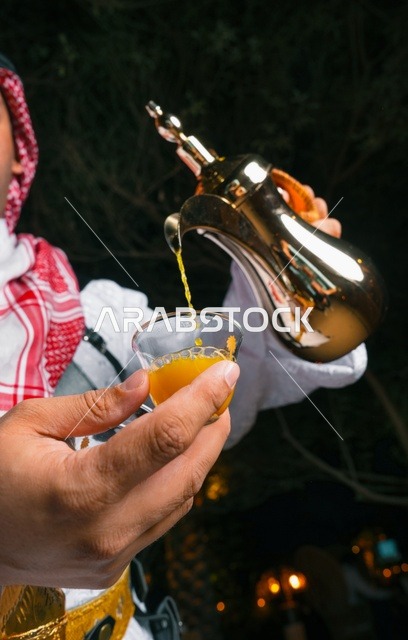 رجل سعودي يصب القهوة العربية من دلة ذهبية