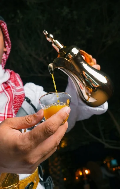 رجل سعودي يصب القهوة العربية من دلة ذهبية