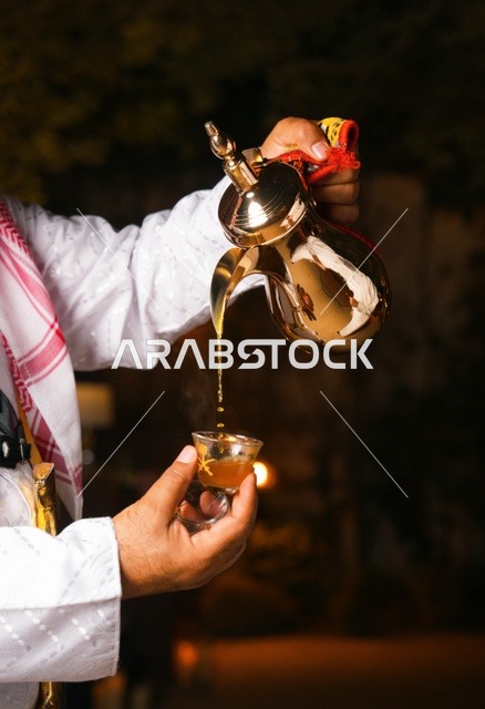 رجل سعودي يصب القهوة العربية التقليدية من الدلة