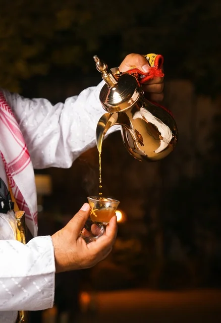 Saudi Man Pouring Traditional Arabic Coffee from Dallah