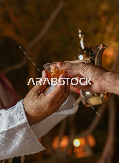 رجل سعودي يقدم القهوة العربية التقليدية ليلاً