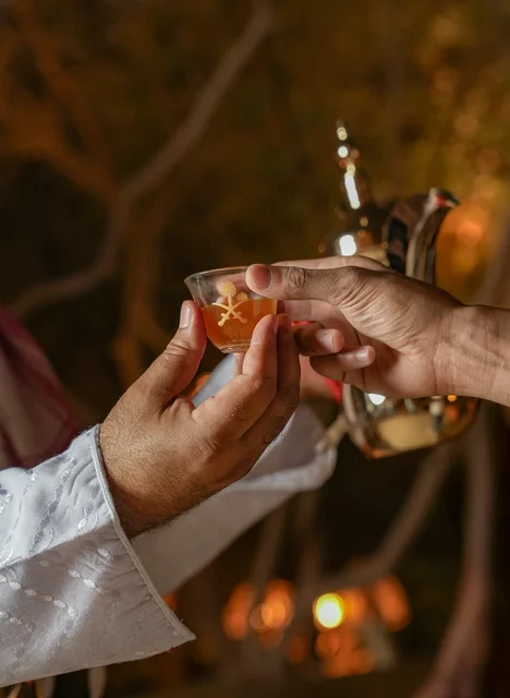 رجل سعودي يقدم القهوة العربية التقليدية ليلاً