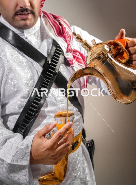 رجل سعودي يصب القهوة العربية التقليدية من الدلة الذهبية