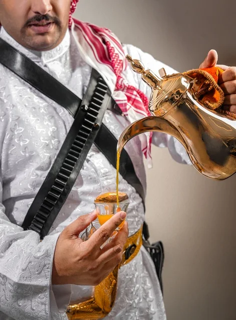 Saudi Man Pouring Traditional Arabic Coffee from Gold Dallah