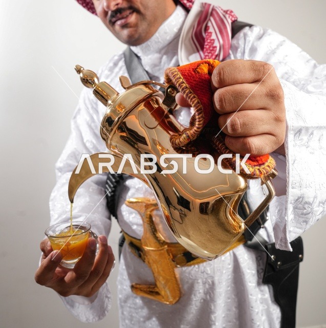 Saudi Man Pouring Arabic Coffee from Golden Dallah