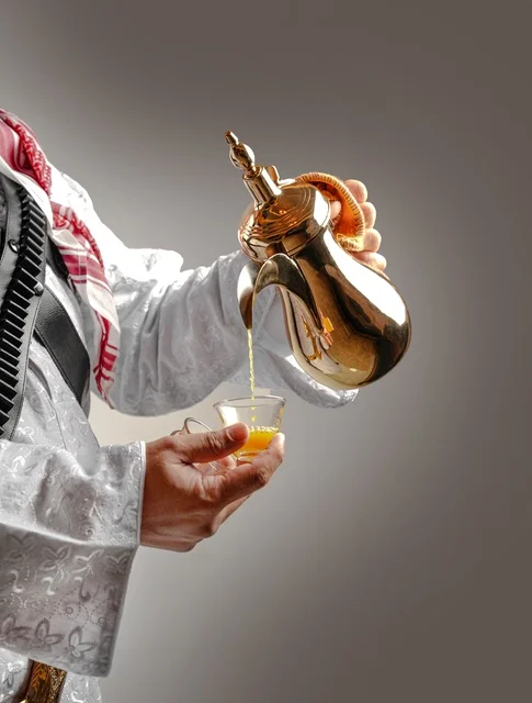Man Pouring Saudi Coffee From Golden Dallah