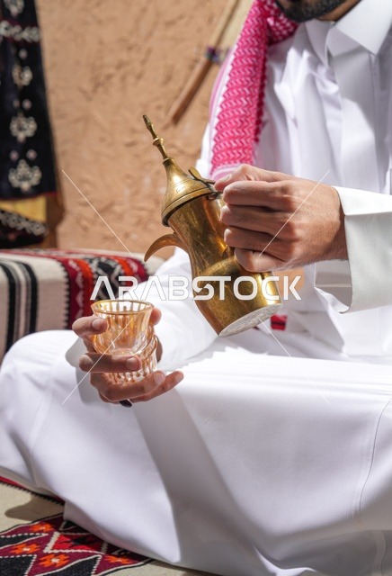 Saudi Man Pouring Arabic Coffee from Golden Dallah