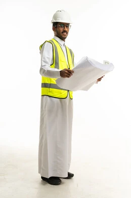 مهندس سعودي يحمل مخططات معمارية بمعدات السلامة