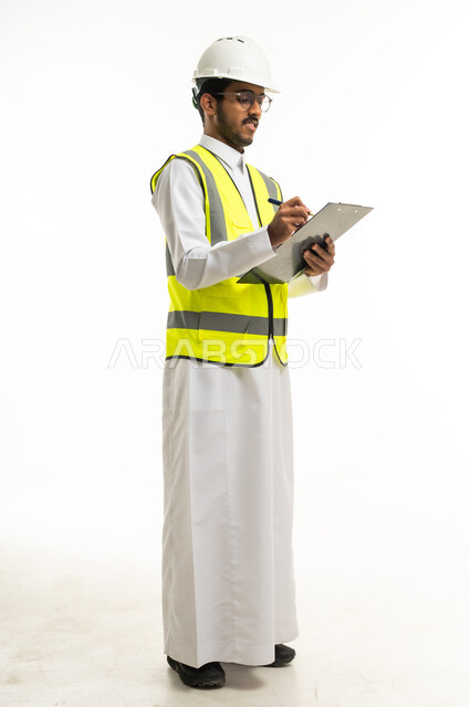 مهندس سعودي بزي السلامة يكتب على لوحة ورقية