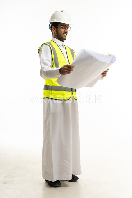 Saudi Engineer in Safety Gear Examining Blueprint