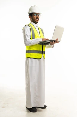 مهندس سعودي يحمل لابتوب بملابس السلامة