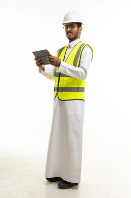 مهندس سعودي يرتدي سترة السلامة ويحمل جهاز لوحي