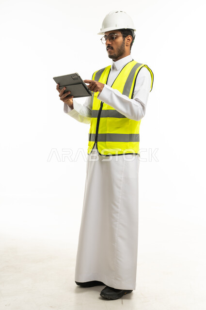 Saudi Engineer in Safety Vest Using Digital Tablet