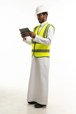 مهندس سعودي بالثوب وسترة السلامة يستخدم جهاز لوحي