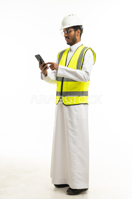 مهندس سعودي بزي السلامة يستخدم الهاتف الذكي