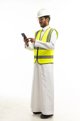 مهندس سعودي بزي السلامة يستخدم الهاتف الذكي
