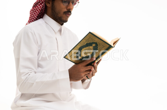 رجل سعودي يقرأ القرآن الكريم بخلفية بيضاء