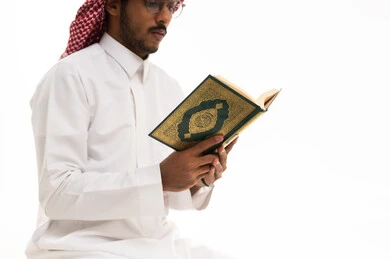 رجل سعودي يقرأ القرآن الكريم بخلفية بيضاء