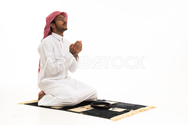 Saudi Man Praying in Traditional Thobe on White Background