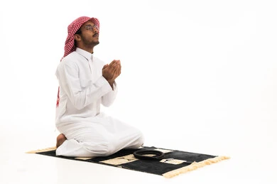 رجل سعودي يصلي بالثوب التقليدي على خلفية بيضاء
