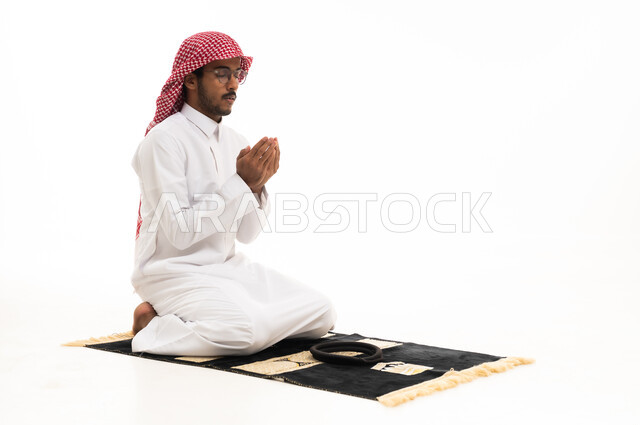 Saudi Man Praying on Rug against White Background