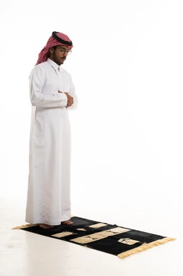 Saudi Man Praying on Rug over White Background