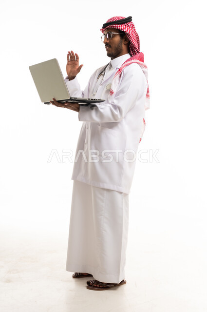 طبيب سعودي يستخدم الحاسوب المحمول بخلفية بيضاء