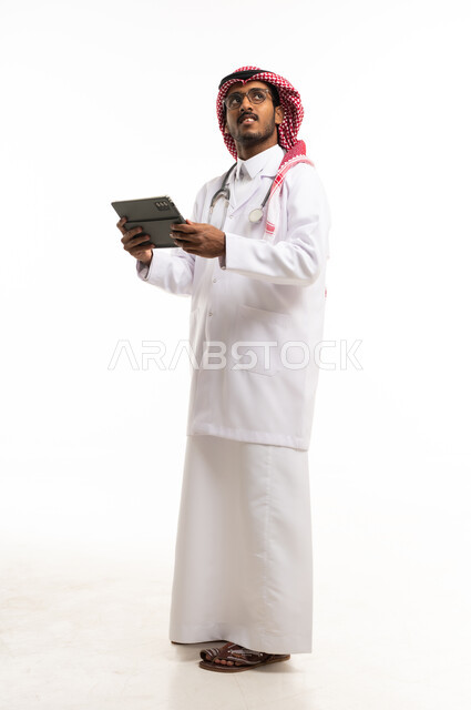 طبيب سعودي مع جهاز لوحي بخلفية بيضاء