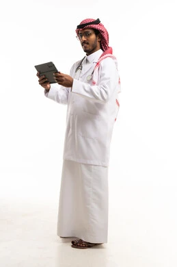 طبيب سعودي يحمل جهاز لوحي على خلفية بيضاء