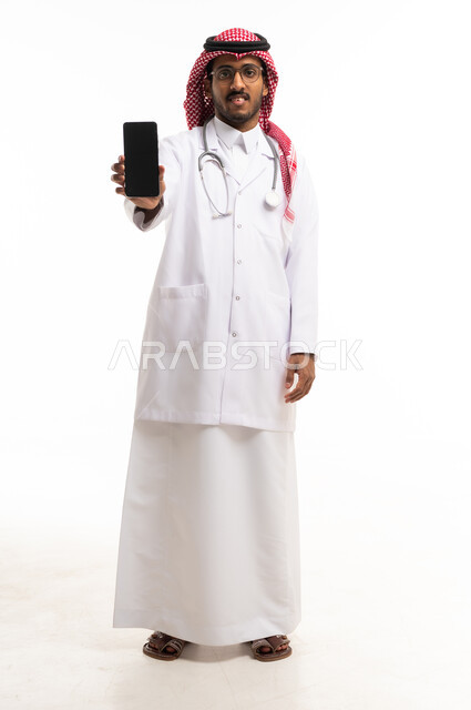 طبيب سعودي يحمل هاتف ذكي على خلفية بيضاء