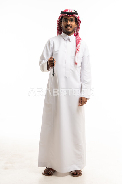 Saudi Man in Traditional Thobe Holding Prayer Beads