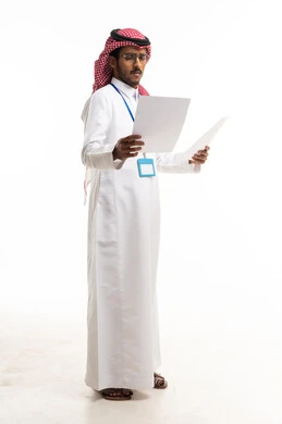 موظف سعودي بالزي التقليدي يراجع الأوراق في الاستوديو