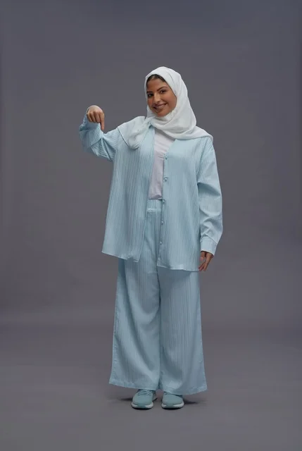 امرأة سعودية تشير للأسفل بملابس محتشمة