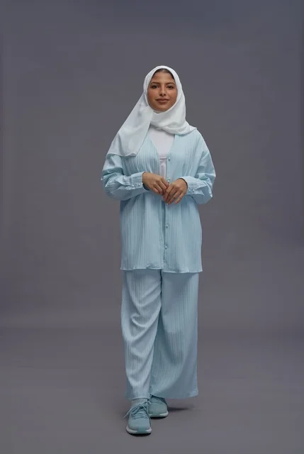 امرأة سعودية بزي محتشم أزرق على خلفية رمادية امرأة سعودية بزي محتشم أزرق على خلفية رمادية