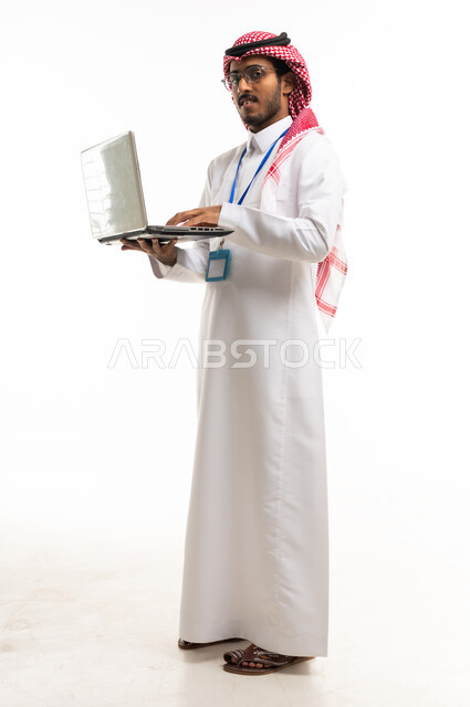 رجل أعمال سعودي يعمل على لابتوب خلفية بيضاء