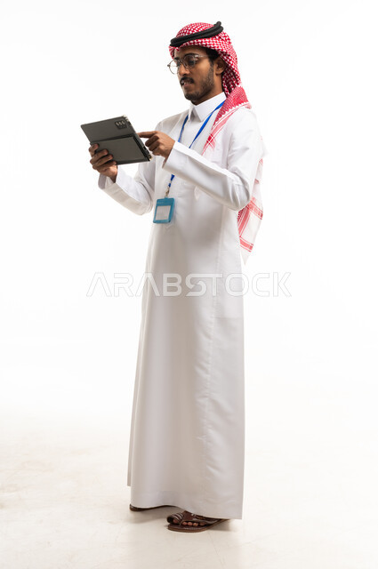 رجل أعمال سعودي يستخدم جهاز لوحي على خلفية بيضاء