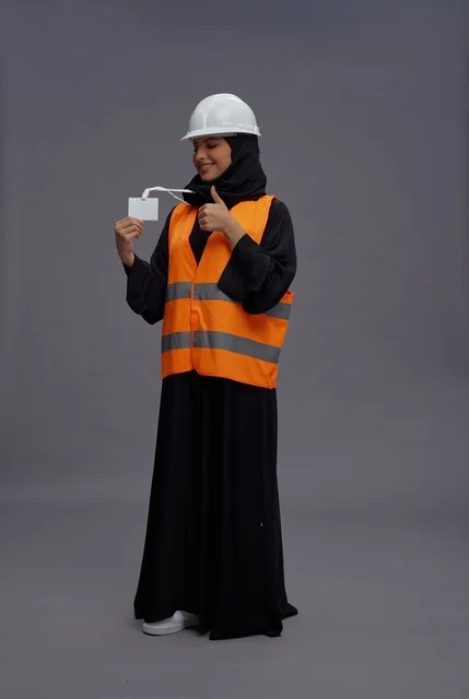 Saudi Female Engineer in Safety Vest Holding ID Card