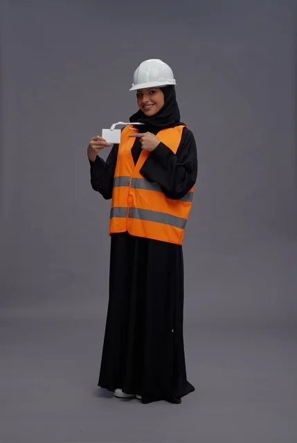 مهندسة سعودية ترتدي سترة السلامة وتحمل بطاقة تعريفية