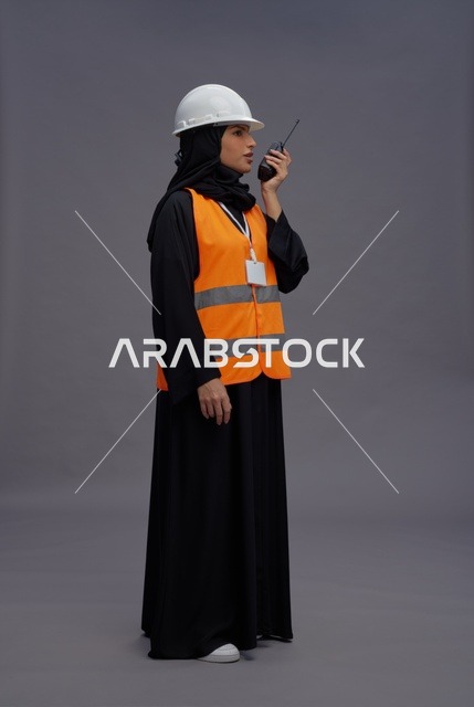 مهندسة سعودية ترتدي سترة سلامة وتستخدم جهاز لاسلكي