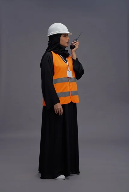 مهندسة سعودية ترتدي سترة سلامة وتستخدم جهاز لاسلكي