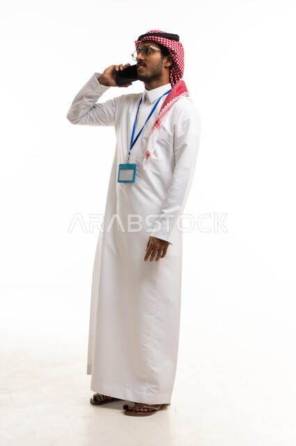 رجل سعودي بالثوب التقليدي يتحدث بالهاتف المحمول