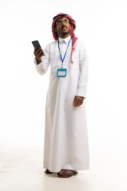 رجل سعودي بالثوب يحمل هاتفاً ذكياً بخلفية بيضاء