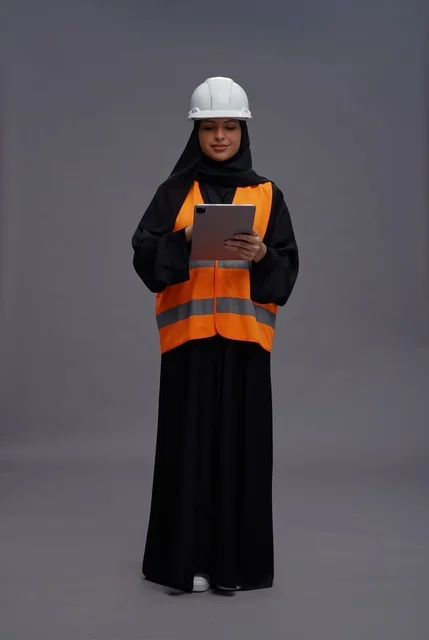 مهندسة سعودية بملابس السلامة تستخدم جهاز لوحي