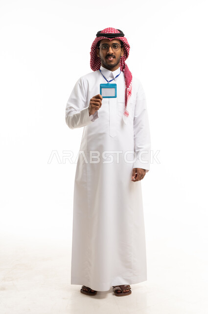 رجل سعودي بالزي التقليدي يحمل بطاقة تعريفية