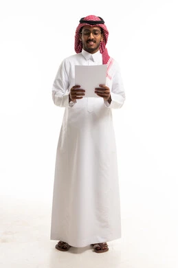 رجل سعودي بالزي التقليدي يقرأ وثيقة ورقية