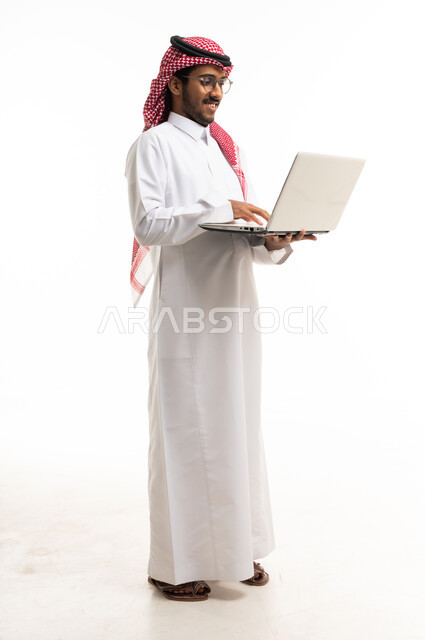رجل سعودي بالثوب التقليدي يستخدم المحمول بخلفية بيضاء