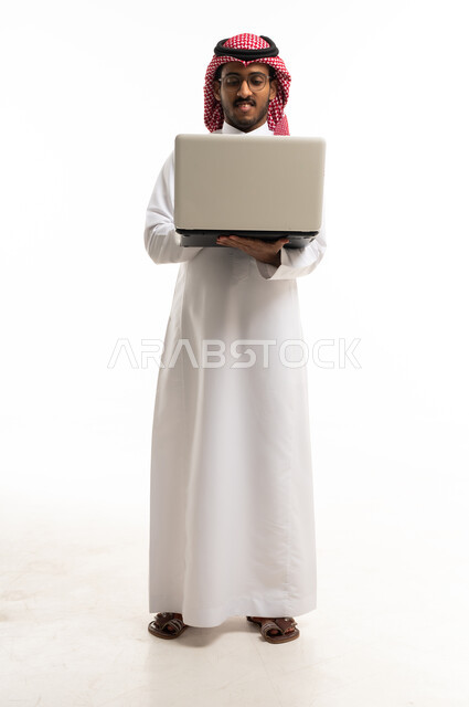 Saudi Man in Traditional Dress Holding Laptop