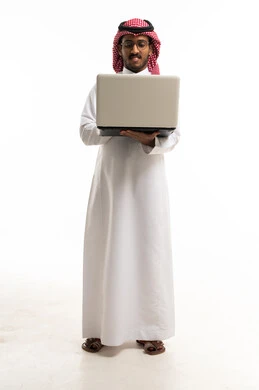 رجل سعودي بالزي التقليدي يحمل كمبيوتر محمول